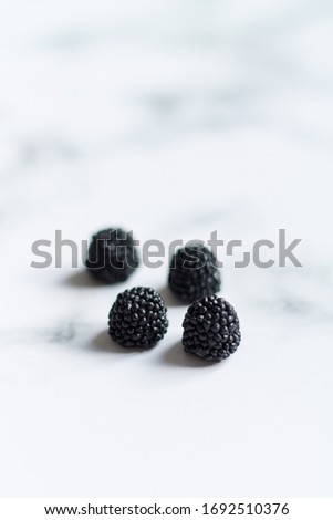 small black berries blackberries on a light background close up