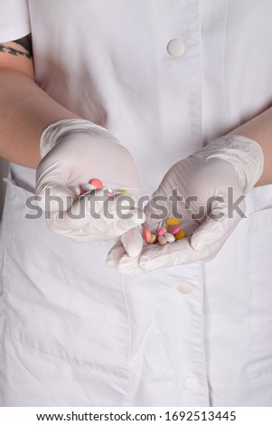 tablets in the hands of a nurse in white rubber gloves