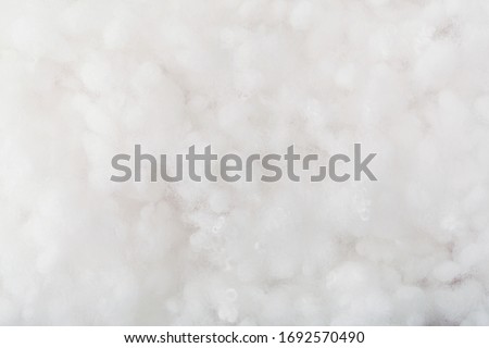 Springy clean white hollow fiber. Holofiber closeup texture. Non-woven synthetic textile Royalty-Free Stock Photo #1692570490