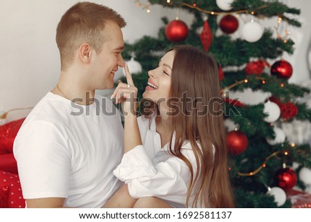 Family in a christmas decorations. Couple near christmas tree. Lady in a white shirt.