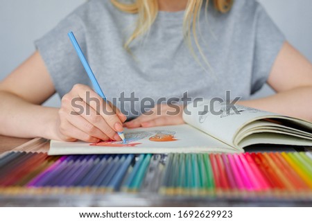 Portrait of lovely girl drawing with colorful pencils. Beautiful woman