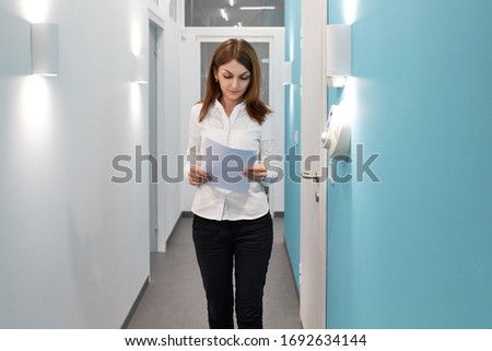 business woman working at the reception in the hospital, girl with documents at the reception in the office, administration