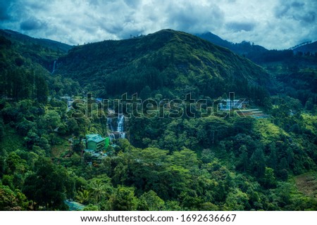 Amazing aerial Mountain View. Green forest and blue cloudy sky. Breathtaking landscape.