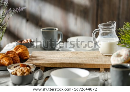 Breakfast on a wooden table in the light of the morning sun on a beautiful holiday day Royalty-Free Stock Photo #1692644872