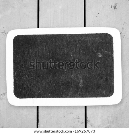  Small wooden framed blackboard on wooden background 