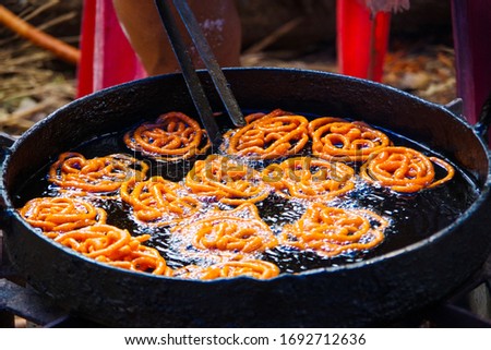 Jalebi is a famous indian sweet. This shows how jalebi are 1st fried in oil Royalty-Free Stock Photo #1692712636