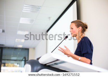 Pretty young business woman giving a presentation in a conference/meeting setting (shallow DOF; color toned image) Royalty-Free Stock Photo #169271552