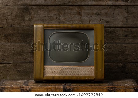 Retro old television receiver on wooden table with dark wooden background. Vintage old TV filter photo