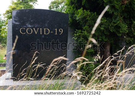 Headstone tombstone or gravestone with COVID-19 letters carved in, Coronavirus global pandemic crisis, many victims and deaths, deadly virus disease, acute respiratory pneumonia infection, RIP concept Royalty-Free Stock Photo #1692725242