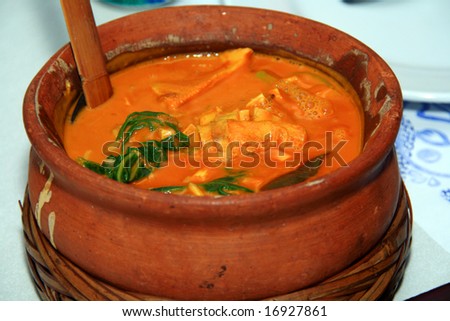 asian peanut stew served in a clay pot