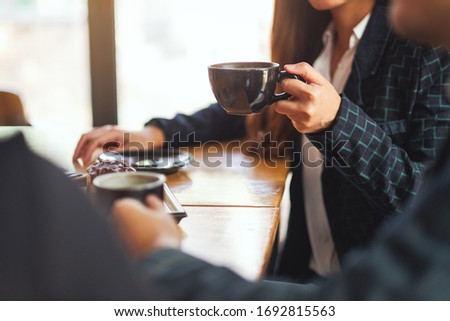 Closeup image of people enjoyed talking and drinking coffee together in cafe