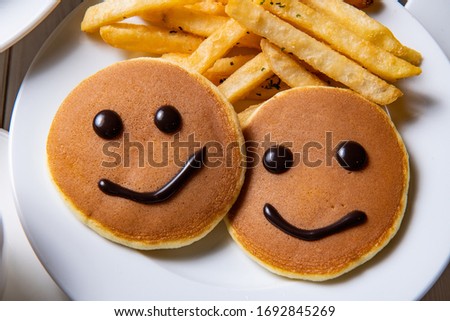 Painted a smiling face with chocolate sauce on the pancake, symbolizing happiness at home