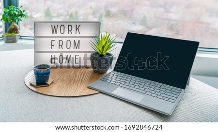 Working from home remote work inspirational social media lightbox message board next to laptop and coffee cup for COVID-19 quarantine closure of all businesses.