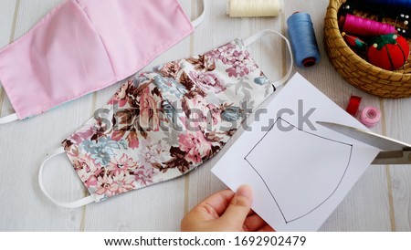 Fabric face mask with cotton fabric flower pattern handmade crafts. This hygienic mask for cover mouth and protection with beautiful sewing fashion. Royalty-Free Stock Photo #1692902479