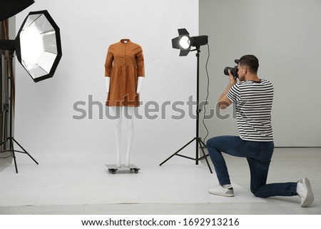 Professional photographer taking picture of ghost mannequin with stylish clothes in modern photo  Royalty-Free Stock Photo #1692913216