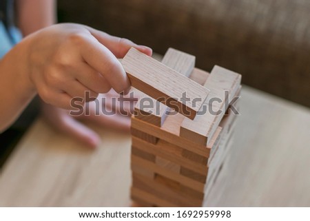 At home, the children play a board game and take out wooden blocks from the tower so that it does not fall. Competition who will win. Spend time at home.