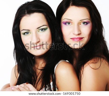 Two girl friends together smiling.Studio shot. 