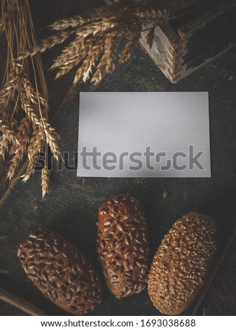 Close up of mockup blank on background of homemade bread making. Mockup of brochure or greeting card in harvest composition with empty place for text.