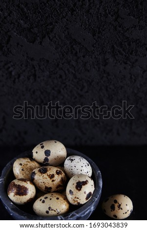 fresh quail eggs photographed on a dark background