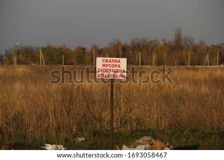 A sign in the field with the inscription in Russian "garbage Dump is prohibited. A fine of 5,000 rubles"