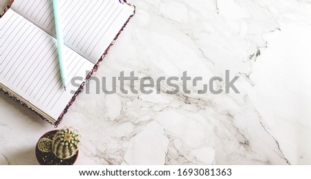 Still life, business, office supplies or education concept : Top view image of open notebook with blank pages laptop on marble background, free copy space 