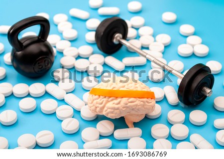 Pharmaceutical supplement for mental fitness, mind health and nootropic drugs concept with human brain with headband, barbell, kettlebell and nootropics Royalty-Free Stock Photo #1693086769