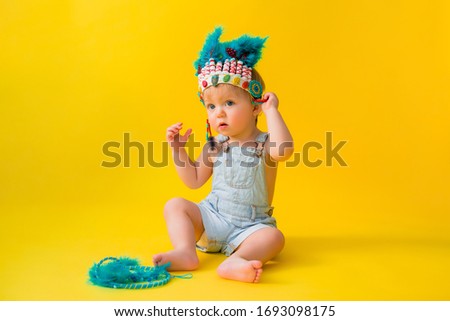 little boy in an Indian costume on a yellow background