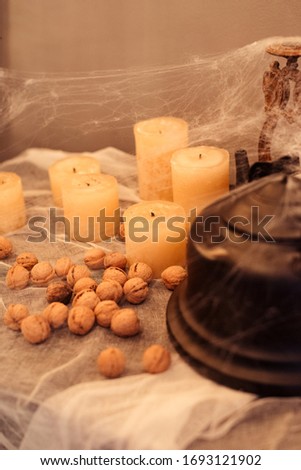 Black teapot with nuts and candles in spider