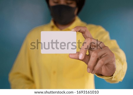 Hand holding  a blank piece of paper. Close up  white business card.That affects meet financial problem and no money to pay debt bill after unemployed from company effect for COVID-19 virus.