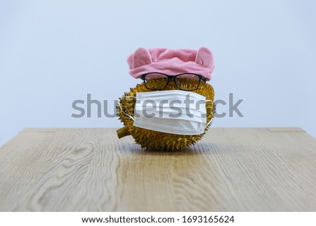 A fruit on a wooden table wearing a disposable medical mask
