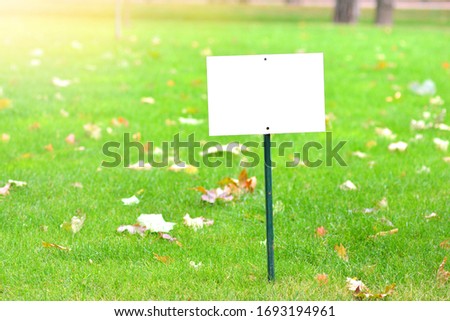 Blank signboard mockup on a green grass lawn