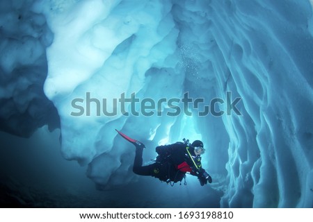 Cool adventure scuba diving in ice cave. Underwater world. Royalty-Free Stock Photo #1693198810