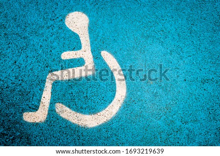 Simple wheelchair symbol on textured blue background