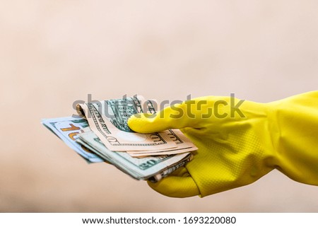 World money concept, hand with gloves receiving, giving or holding USD banknote, isolated on blurred background. Corona virus COVID-19 outbreak. Concept of prevention virus spread