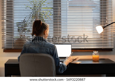 home office woman working on computer at dusk white screen for copy space