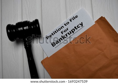 Petition File For Bankruptcy text on document above brown envelope and gavel. Healthcare or medical concept