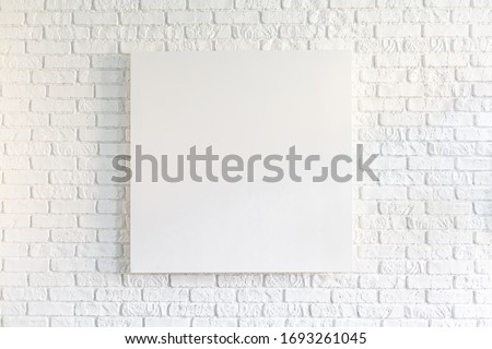 Canvas poster in vintage loft interior, background with pace for text, template design. Empty picture on white old brick wall. Mock up template for adding your content.
