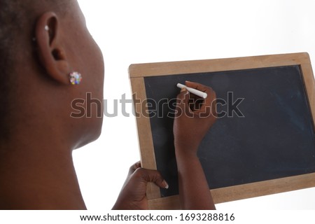 
close up of hands of a young black african woman shouting on a blackboard with a chalk on white isolated studio background