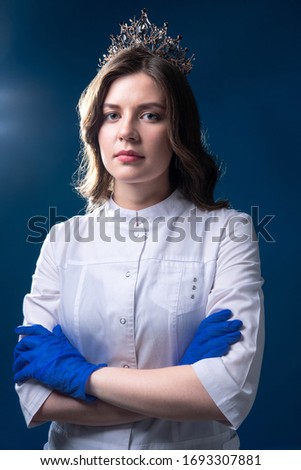 The concept of preventing the spread of the epidemic and treating coronavirus. Portrait of a serious doctor in gloves over the blue background