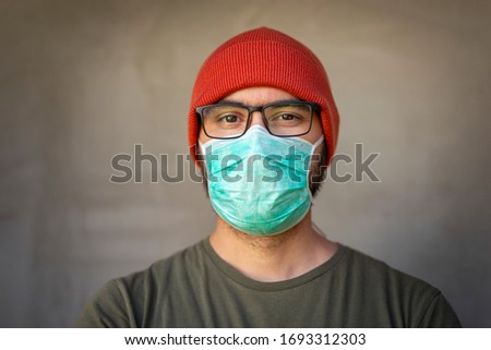 Portrait of man wearing medical face protection mask; air pollution or allergies protection, coronavirus, bacterial and viral respiratory infections prevention concept