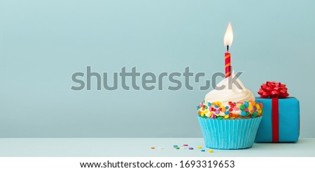 Birthday cupcake with candle and gift box Royalty-Free Stock Photo #1693319653