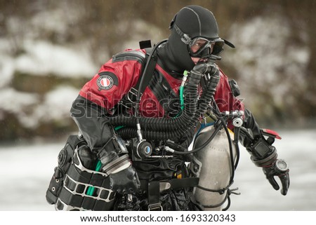 Scuba diver with rebreather after the dive in frozen quarry in the middle of Europe Royalty-Free Stock Photo #1693320343