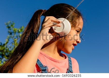 girl plays phone at the sun