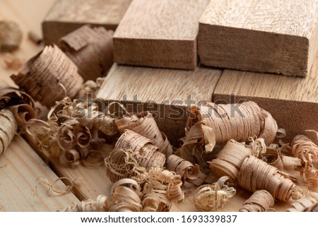 Mahogany wood block and wood shavings. Wood shavings of different sizes from woodworking. Royalty-Free Stock Photo #1693339837