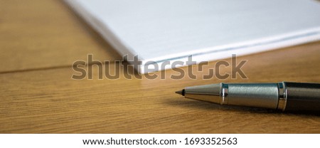 notebook and pen on wood table