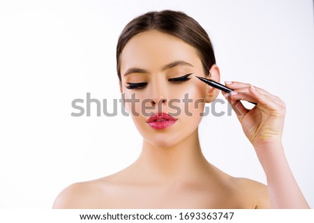 Eyeliner. Close-up beauty shot of young pretty model with bright make-up. Beautiful girl with make up apply cosmetic eyeliner. Beauty and make up Royalty-Free Stock Photo #1693363747