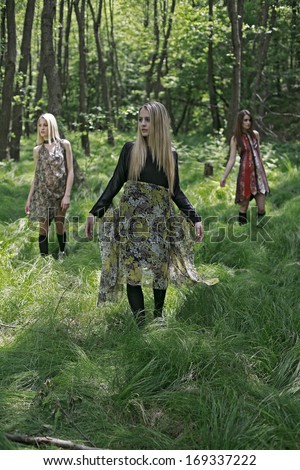 girls standing in the green woods, beautiful girls in a tall forest grass 