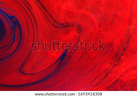 streaks of red and blue paint dissolve in water. Smoke, a witch's potion, the texture of flares. Abstract background, texture.