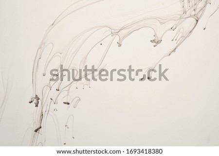 streaks of black paint dissolve in water. Smoke, a witch's potion, the texture of flares. Abstract background, texture.
