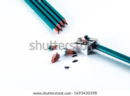 Sharpener and pencils lie on a white background